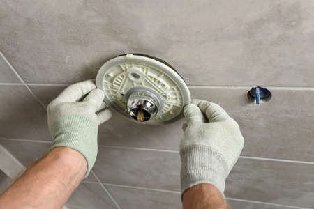 The worker's hands are mounting a built-in faucet.の写真素材