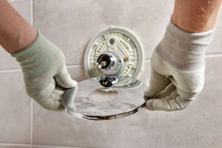 The worker's hands are mounting a built-in faucet.の写真素材