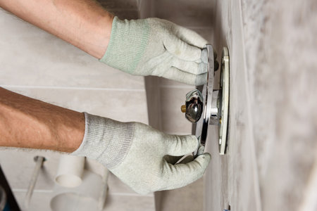 The worker's hands are mounting a built-in faucet.