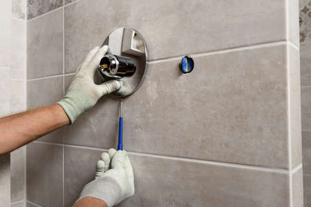 The worker's hands are mounting a built-in faucet.の写真素材