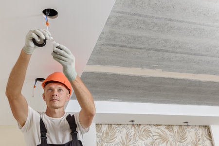 The electrician is installing LED spotlights on the ceiling.の写真素材