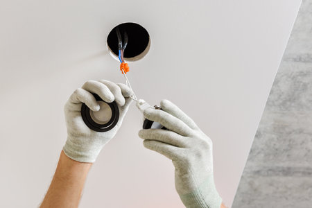 An electrician is installing LED spotlights on the ceiling.の写真素材