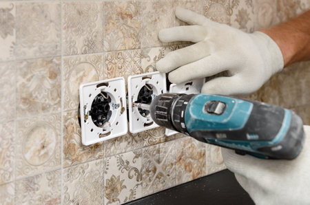 An electrician is installing switches and sockets on the wall.の写真素材