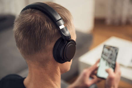 The man in headphones and with a smartphone. Back view.の写真素材