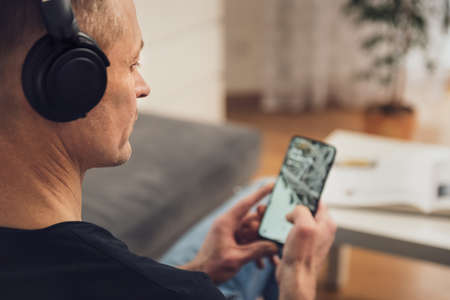 The man in headphones and with a smartphone. Back view.の写真素材