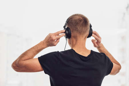 The man in headphones on the background of the window. Back view.の写真素材