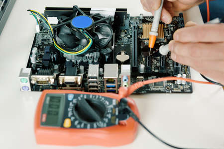 A technician checks the serviceability of the computer motherboard.の写真素材