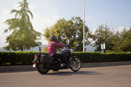 Rear view of a man sitting on a motorcycle in the park