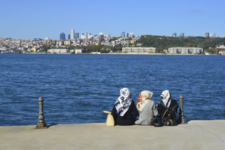 Istanbul, Turkey - October 20, 2013: Sea of Marmara, the Bosphorus. Middle East three women sitting on the beach, looking at the sea resting.のeditorial素材