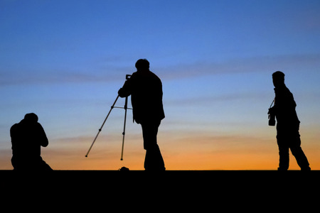 Sunrise silhouette of photographers shootingの写真素材