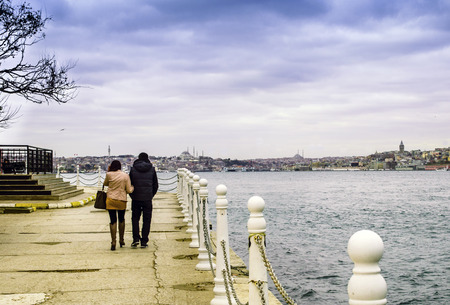 Istanbul, Turkey - December 04, 2013: Uskudar district a couple walking on the beach. View from the Anatolian side of Istanbul viewsのeditorial素材