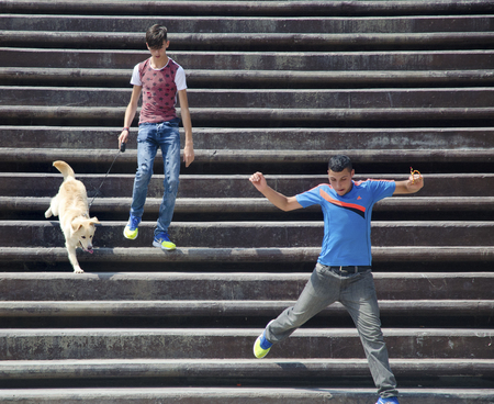 Istanbul, Turkey - July 31, 2016: Group of young people having fun on stairs, talking laughing and running, with golden retriever dog.のeditorial素材