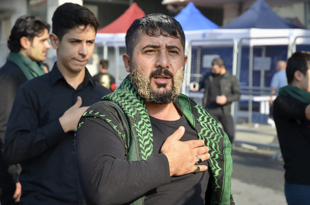 Istanbul, Turkey - October 11, 2016: Shia Muslim men shout Islamic slogans as they mourn during an Ashura procession. Muslims worldwide marks Ashura Istanbul Shiite community. Turkish Shia Muslims mourning for Imam Hussain. Caferis take part in a mourningのeditorial素材