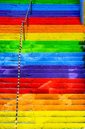 The concrete stairs on the street are painted in rainbow colors. Background