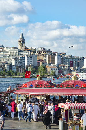 Istanbul, Turkey - July 26, 2016: Fish sandwich (Balik ekmek) at the Eminonu pier near the Galata Bridge. 
Background The Golden Horn is seen and the Galata Tower. "Tarihi Eminonu Balik Ekmek" the fish (mackerel) is directly grilled on the boat and then pのeditorial素材