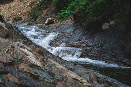 Mountain river runs through the rocksの写真素材
