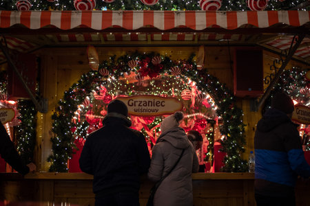 A festive Christmas market on the main square in Wroclaw, Poland, with twinkling lights, decorated stalls, and cheerful holiday atmosphere in the historic city center.の写真素材