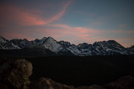 The sunset atop Mount Kopieniec in Zakopane, Poland, casts a warm glow over the Tatra Mountains,...