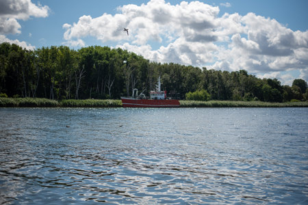 The bay in MiÄdzyzdroje, Poland, features tranquil waters surrounded by sandy beaches and lush greenery, offering a picturesque spot for relaxation and outdoor activities.の写真素材