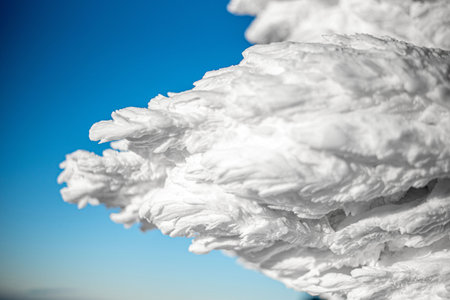 On a mountain, a table and cross amidst snow, with sunny weather and clear skiesの写真素材