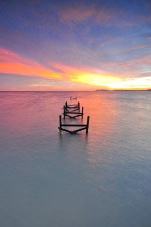 Beautiful dusk sky over the old pier in the sea.の写真素材