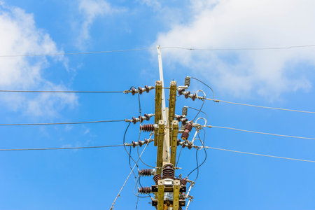 electric pole and lines againts bule sky background