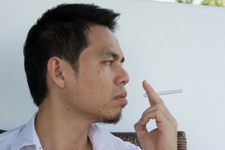 stressful businessman smoking an cigarette on white backgroundの写真素材