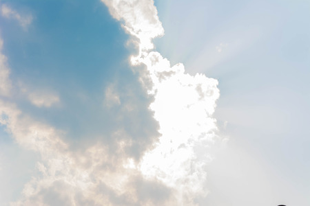 ray of sunlignt glow behind the cloud on the skyの写真素材