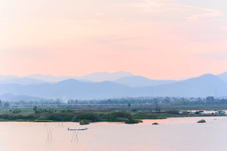 photo of reflection view of sun when sunset at dam on the evening の写真素材