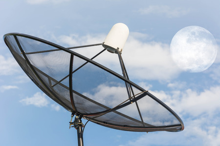 Satellite dish against cloudy sky with moon on sky . . Elements of this image furnished by NASAの写真素材