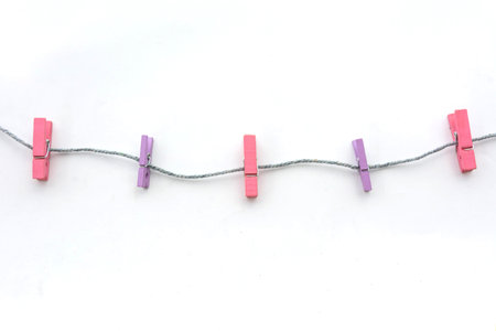 clothespins hanging on rope white background