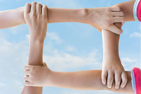 hands holding each other arms making strength on sky background