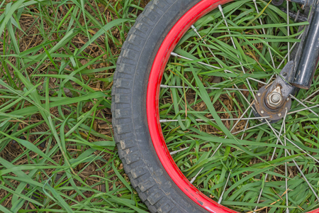 wheel of old bicycle on green grass backgroundの写真素材