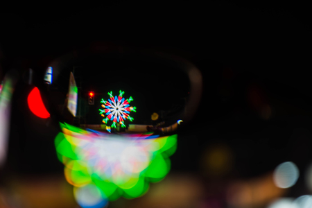 Abstract motion blur of lights on street in festival through glassesの写真素材