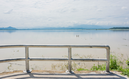 fences against lake with mountain and blue skyの写真素材