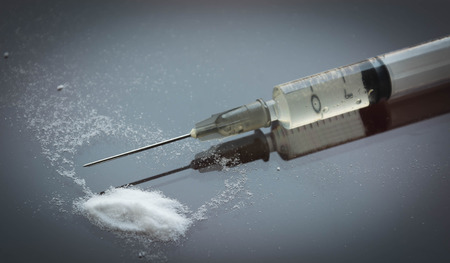 syringe and heroin on black glass with reflection and shadow edge. Drug addictionの写真素材