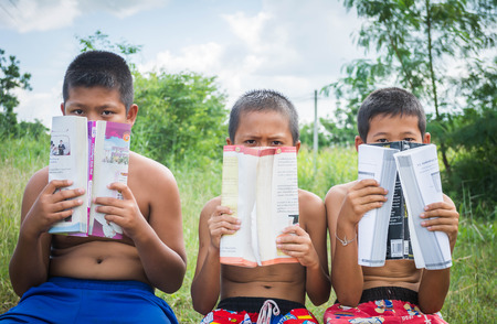 poverty countryside of boys sitting together reading books and enjoy, lack of education conceptのeditorial素材