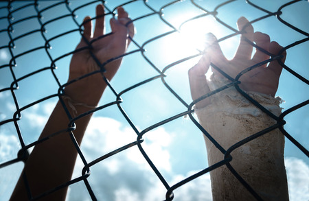 the boy holding the cage with sky background, imprisoned, retarded, Child Abuseの写真素材