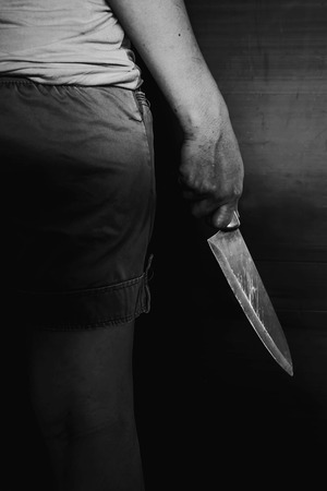 murdered holding knife in white tone with shadow edgeの写真素材