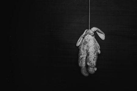 horror hanged doll, murdered on black background in white tone with shadow edgeの写真素材