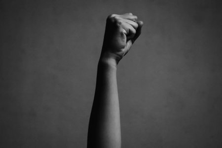 blurry and soft focus of fist raised in the air in white toneの写真素材