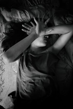 woman laying on bed with fear, violence , sexual abuse, human trafficking with shadow edge in white toneの写真素材