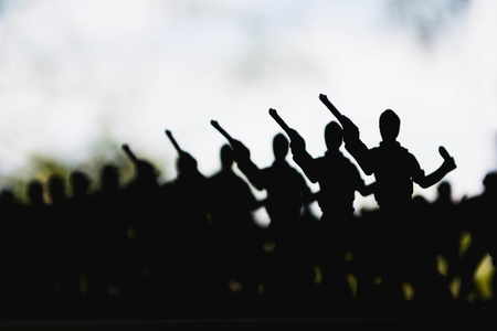 silhouette of soldiers in war on cloudy sky backgroundの写真素材