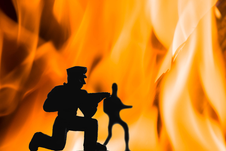 silhouette of soilders in war with blazing fire and flame backgroundの写真素材