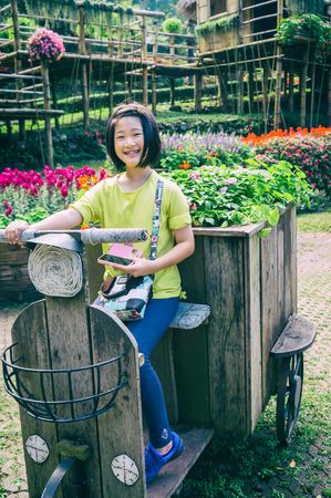 outdoor portrait of girl riding wooden motobike in park, vintage styleの写真素材