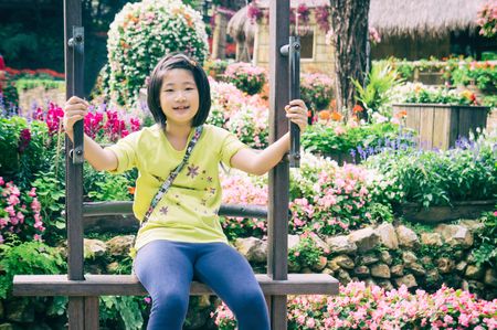 outdoor portrait of girl riding wooden Ferris wheel in park, vintage styleの写真素材