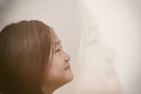 exposure cute happy girl smiling and looking up on whiteの写真素材