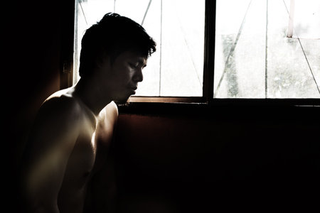 depressed and hopeless man alone in the room with window