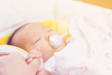 sweet baby sleeping  on bed at home with gradientの写真素材