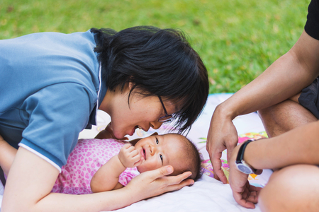 mother and father parenting baby on parkの写真素材